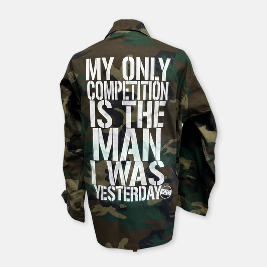 Close-up of a jacket with the text 'My only competition is the man I was yesterday', capturing the essence of personal growth and ambition by KIC NYC.